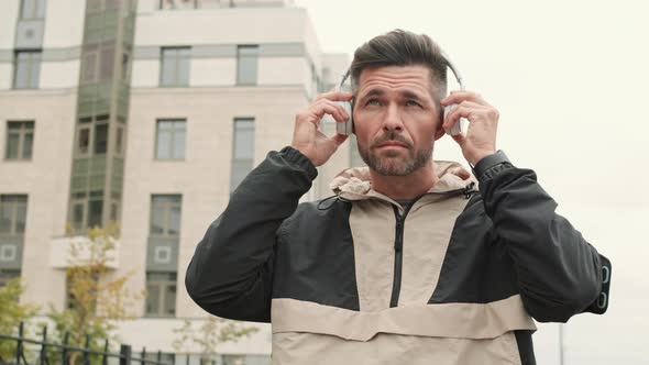 Sporty Man Putting on Headphones and Starting a Run alt