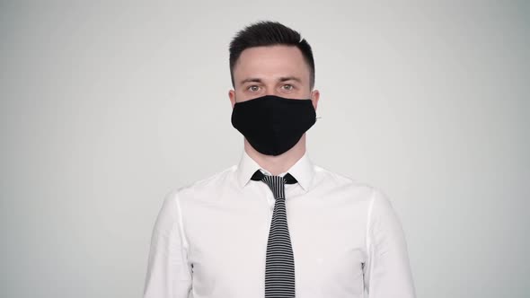 Portrait of Male Wearing White Shirt Tie and Mask. Standing on Wall Background. Avoidance