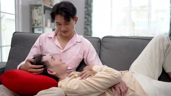 Asian young gay man couple lying on boyfriend's lap in house.  alt