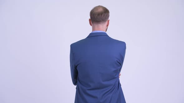 Rear View of Bearded Businessman Thinking and Waiting