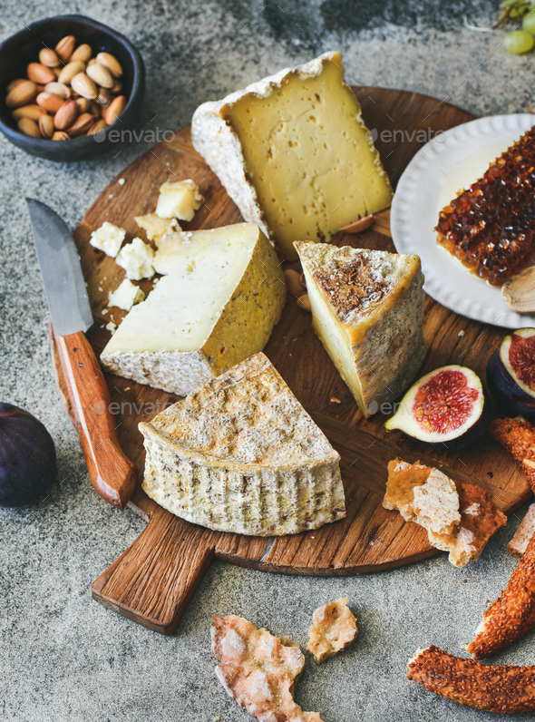 Cheese assortment, figs, honey, fresh bread and nuts - Stock Photo - Images