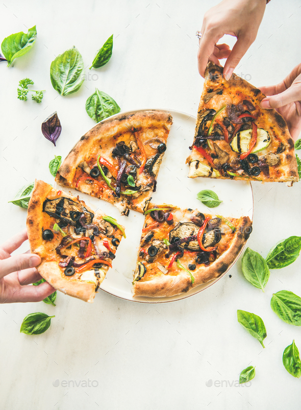 People's hands taking Freshly baked vegetarian pizza over marble background - Stock Photo - Images