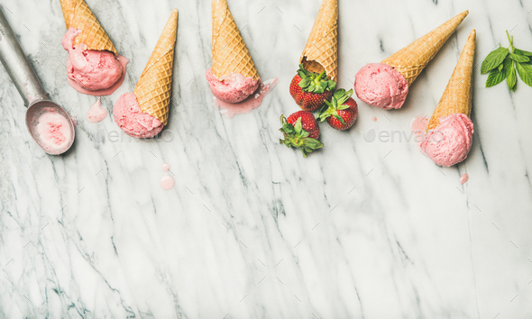 Flat-lay of homemade yogurt strawberry ice cream in waffle cones - Stock Photo - Images