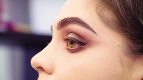 Makeup Artist Painting Black Eyeliner on the Eyes