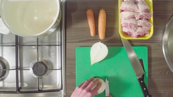 Chef Cutting Onions on Chopping Board