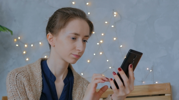 Woman Using Vertical Black Smartphone at Home