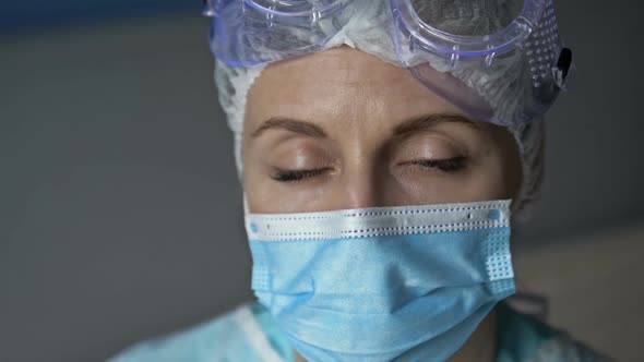 Portrait of a Tired Female Doctor or Nurse Taking Off Her Protective Mask