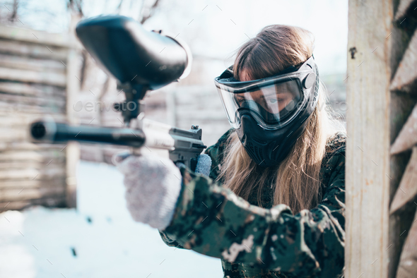 Female paintball player with marker gun in hands - Stock Photo - Images
