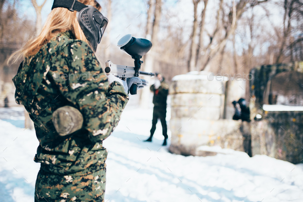 Female paintball player shooting at the enemy - Stock Photo - Images