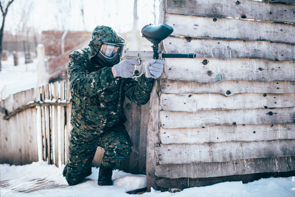 Paintball player with marker gun in hands attack - Stock Photo - Images