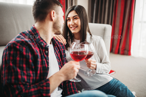 Love couple watches movie and drinks red wine - Stock Photo - Images