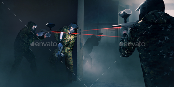 Paintball team in battle, guns with a laser sight - Stock Photo - Images
