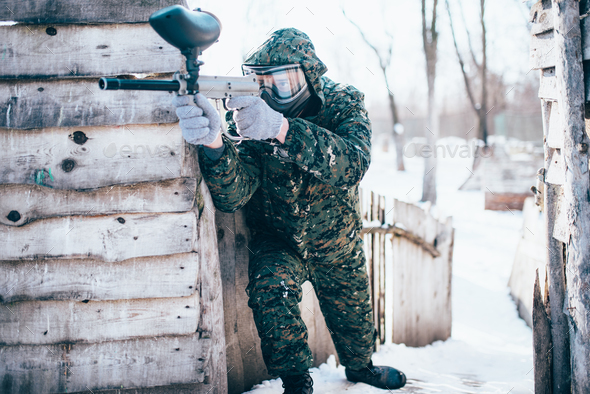 Paintball player with marker gun in hands attack - Stock Photo - Images