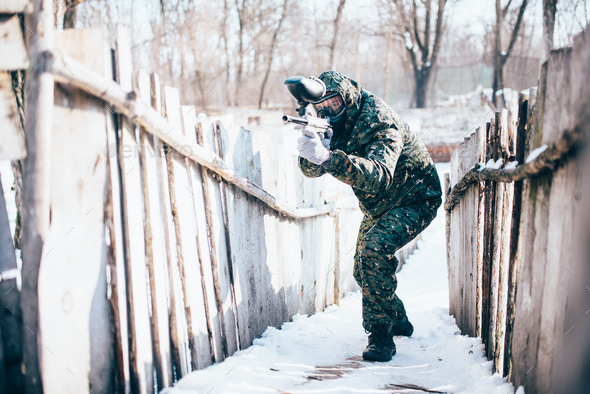 Paintball player with marker gun in hands attack - Stock Photo - Images