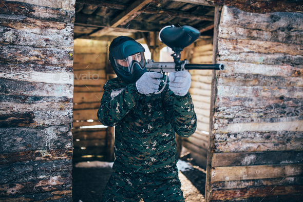 Paintball player with marker gun, front view - Stock Photo - Images