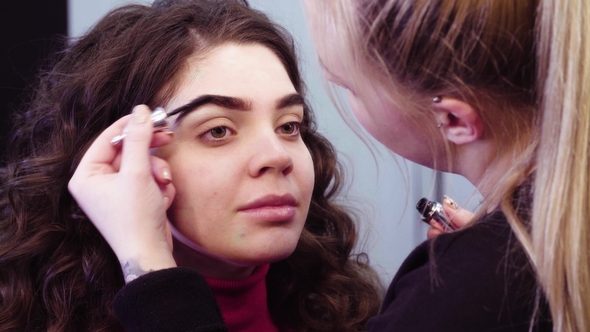 The Makeup Artist Coloring Eyebrow of the Model