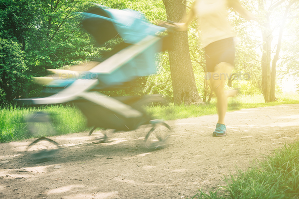 Running woman with baby stroller enjoying summer in park Stock Photo by blas