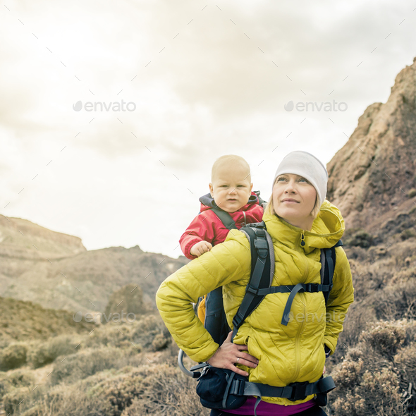 Superhero mother with little boy travelling in backpack - Stock Photo - Images