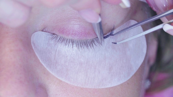 Woman Eye. Eyelash Extension Procedure in Salon