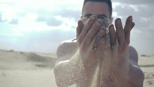 Man Pours Sand through His Fingers