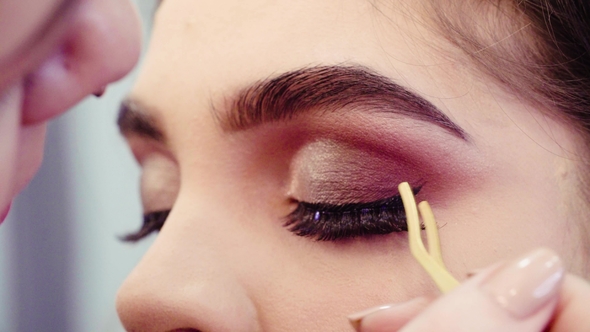 Makeup Artist Glueing False Eyelashes to the Eyes