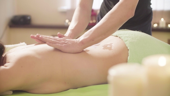 Massagist Doing Massage of the Woman's Back