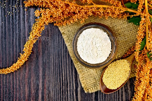 Flour amaranth in bowl with spoon and flower on board top - Stock Photo - Images