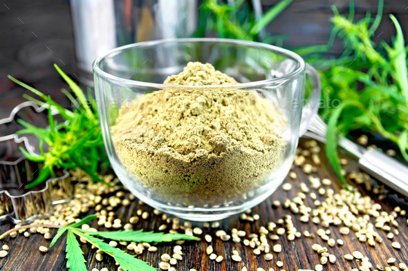 Flour hemp in glass cup on dark board - Stock Photo - Images