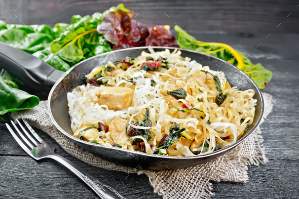 Funchoza with chard and meat in pan on black board - Stock Photo - Images