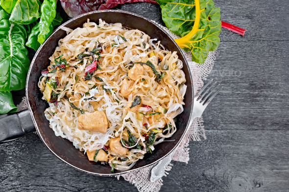 Funchoza with chard and meat in pan on board top - Stock Photo - Images