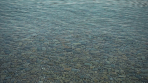Stone Slowly Falling on Calm Water Surface