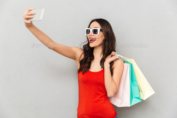 Cheerful brunette woman in casual clothes and sunglasses making selfie - Stock Photo - Images