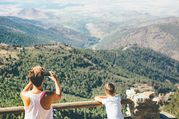 Young woman takes picture at the mountain - Stock Photo - Images