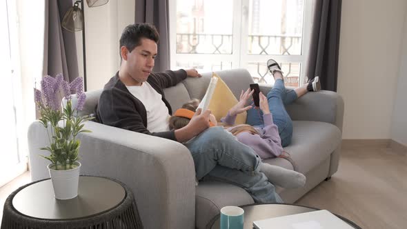 Young couple relaxing and spending time together on the couch while staying at home. alt