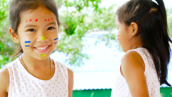 Two girls playing and having fun with their painting hand