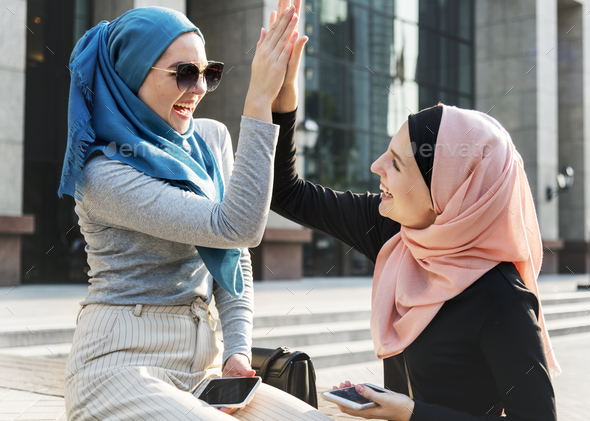Islamic friends high five and smiling - Stock Photo - Images
