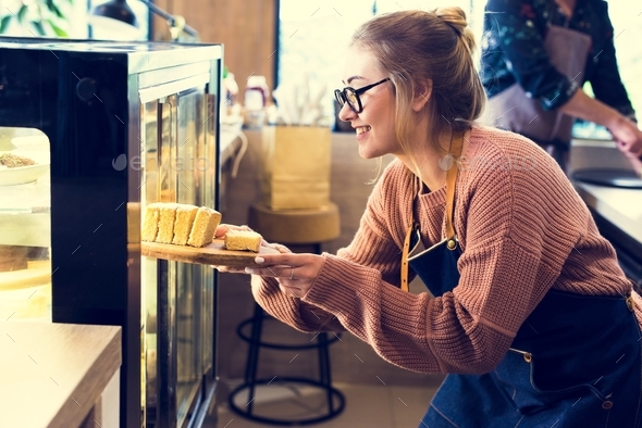 Woman getting cake out of the display fridge Stock Photo by Rawpixel