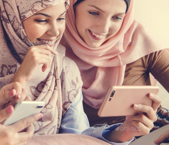 Group of islamic women talking and watching on the phone together - Stock Photo - Images