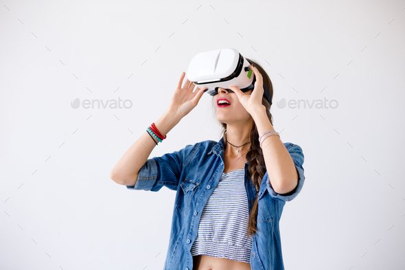 Young woman with VR glasses in studio - Stock Photo - Images