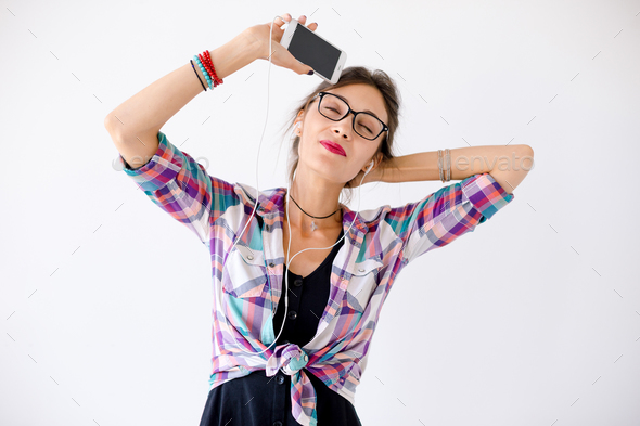 Close-up portrait of young girl with headphones listening music - Stock Photo - Images