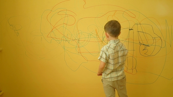 Little Boy Drawing on the Wall at Home