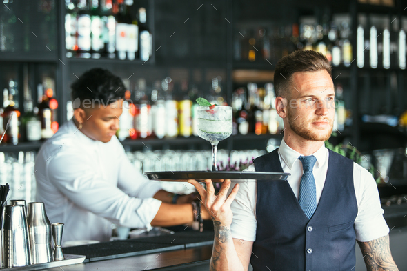 Elegant waiter serving a cocktail - Stock Photo - Images