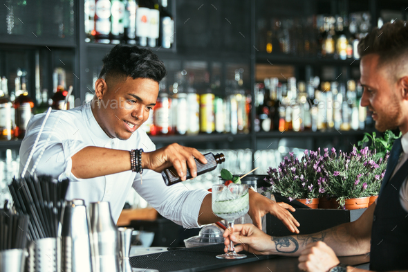 Bartender prepares a cocktail to a waiter - Stock Photo - Images