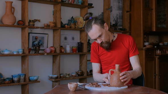 Professional Potter Shaping Dry Clay Jar with Special Tool in Pottery Workshop