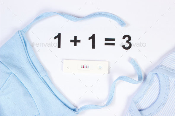 Pregnancy test with positive result and clothing for newborn, expecting for baby concept - Stock Photo - Images