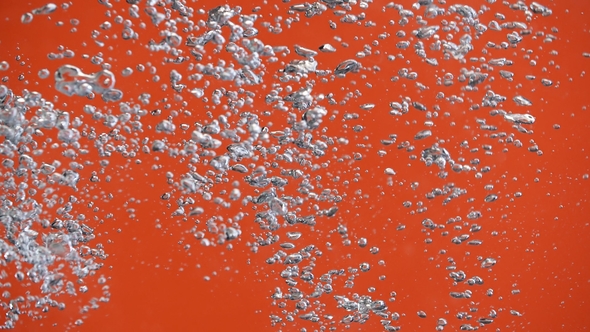 Air Bubbles in the Pouring Water Splash on Orange Background