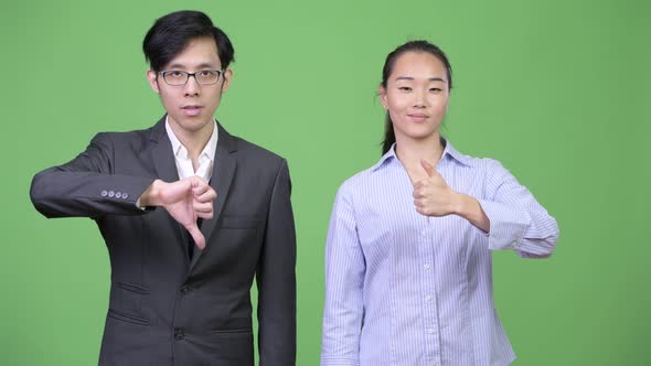 Young Asian Business Couple Having Different Decisions Together