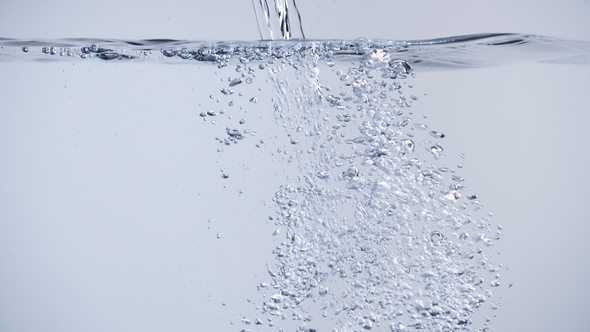 Pouring Water with Air Bubbles and Splashes on Clean White Background ...