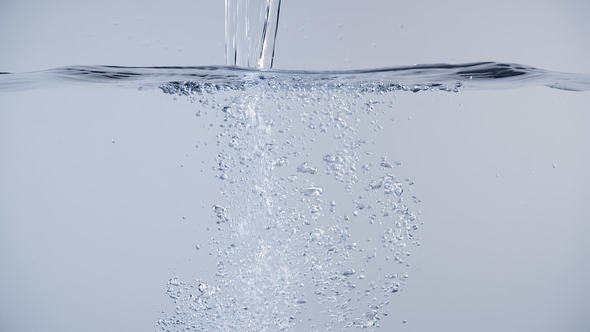 Pouring Water Isolated with Air Bubbles and Splashes on Clean Background Shot in alt