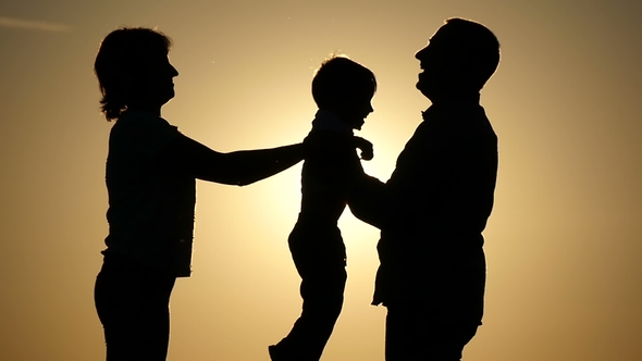 Silhouette of Father of Mother and Child. Mother Passes the Child To Her Father. The Concept of a